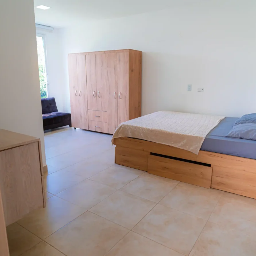 Habitación moderna y funcional con cama con almacenamiento y armario grande, ideal para alquiler cerca de Lago Calima.