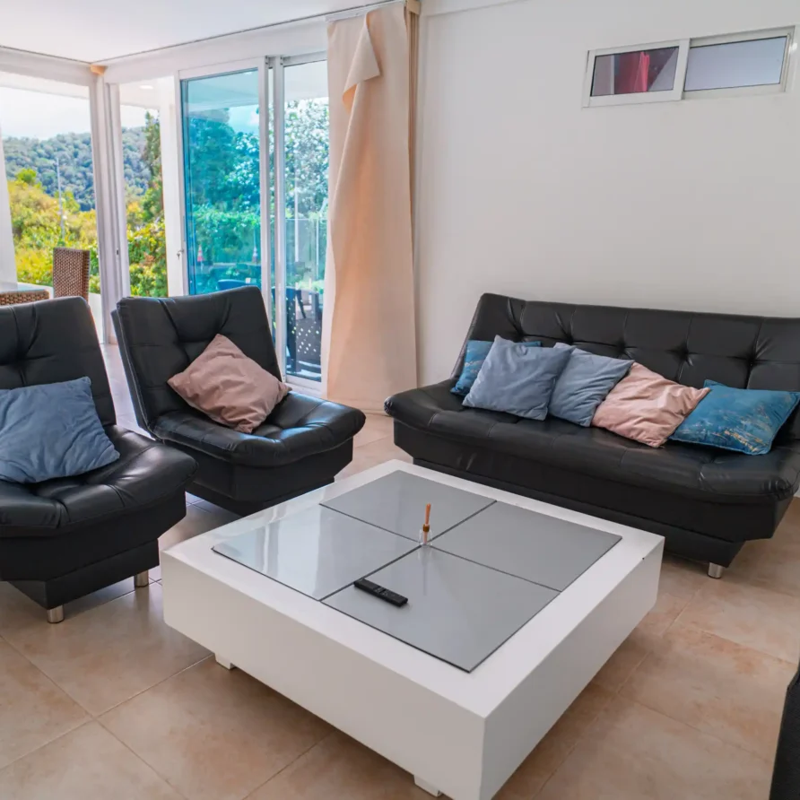 Acogedora sala de casa o cabaña en Calima El Darién, con sillones cómodos y salida a balcón con vistas a montañas verdes.