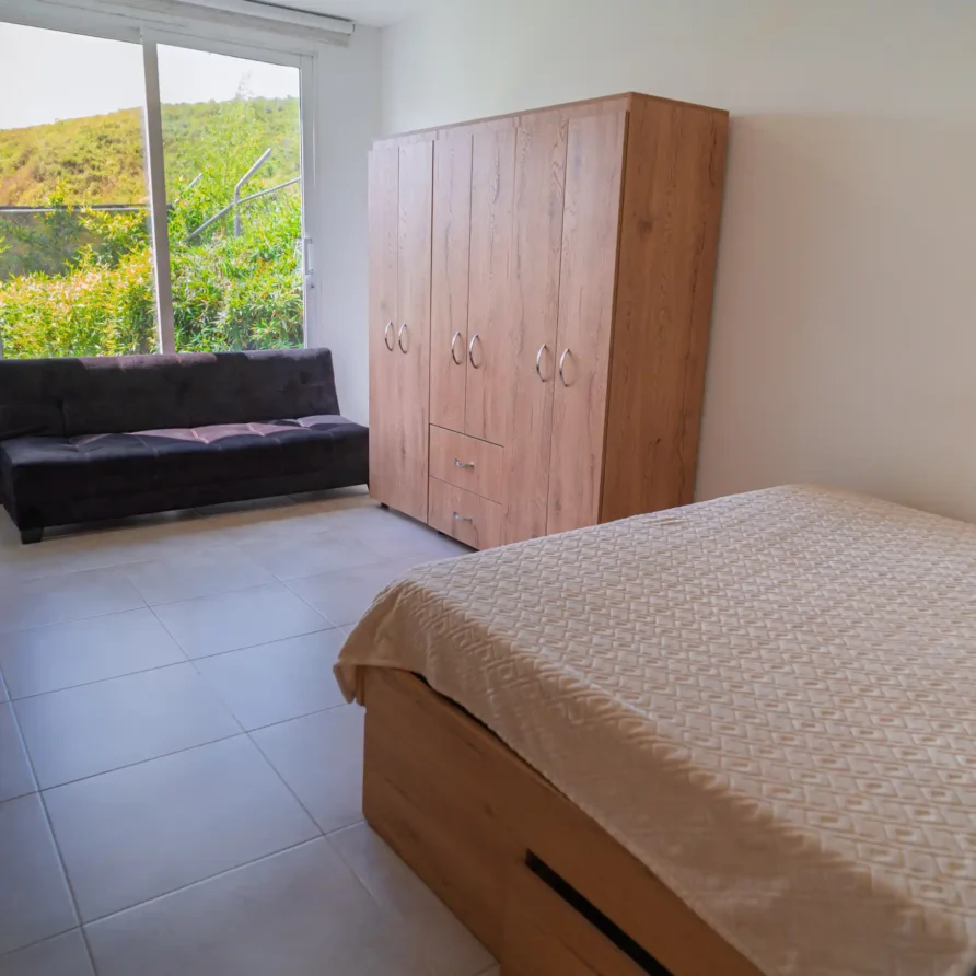 Habitación moderna en Casa Curva Bonita, Calima El Darién, con cama, sofá y vista exterior natural, ideal para el descanso.