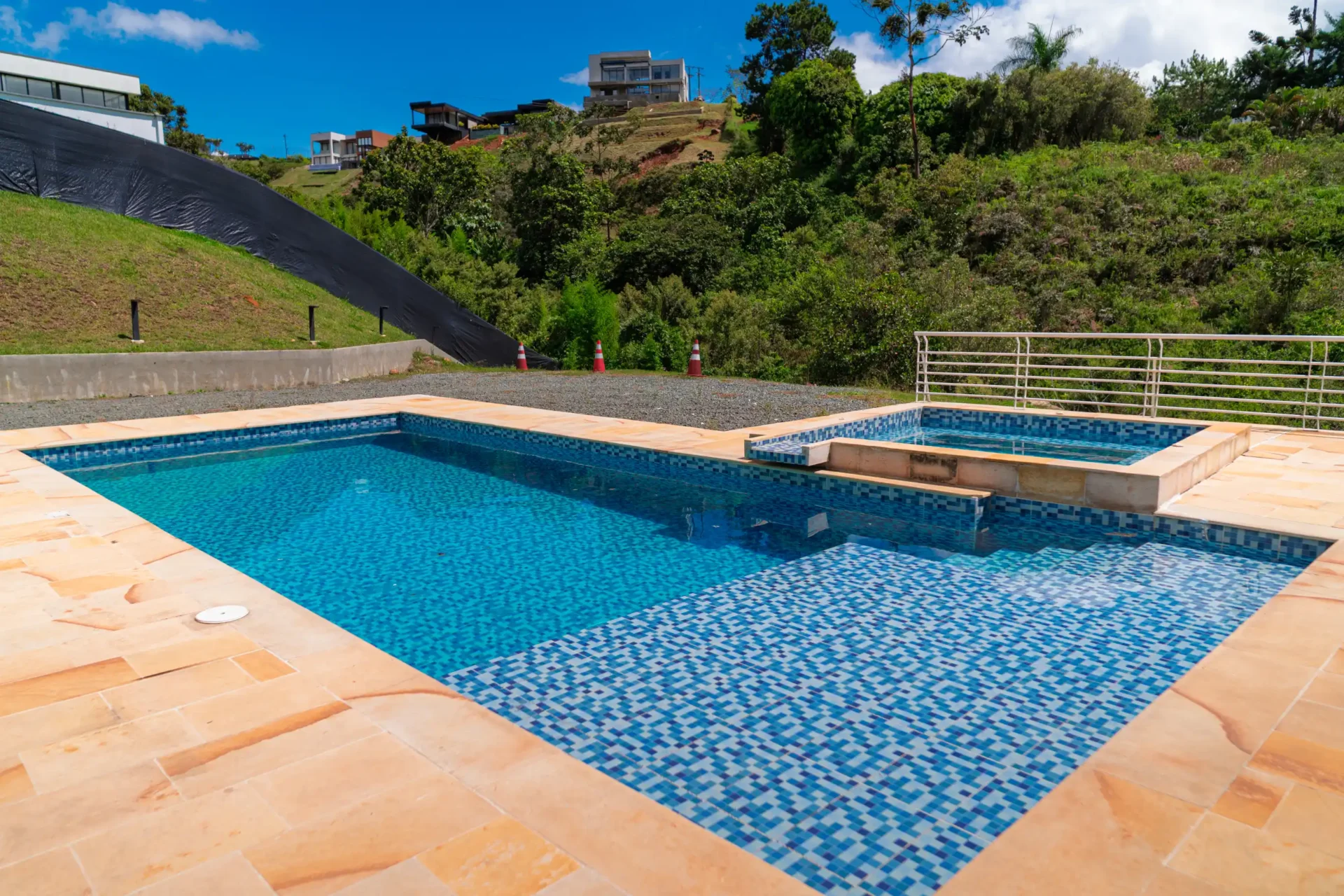 Área de piscina y spa con mosaicos azules, en una propiedad con vista a la naturaleza en Calima El Darién.