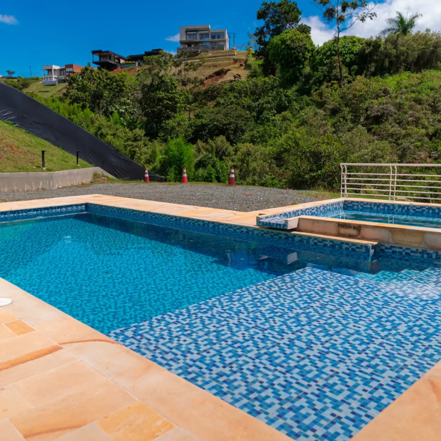Área de piscina y spa con mosaicos azules, en una propiedad con vista a la naturaleza en Calima El Darién.
